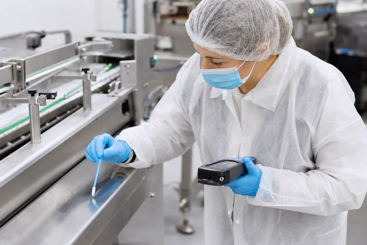 Técnica realiza verificação de higiene por swab em uma linha de produção de alimentos